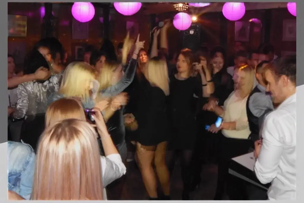 Guests dancing and enjoying a lively karaoke party at Recept restaurant in Belgrade.