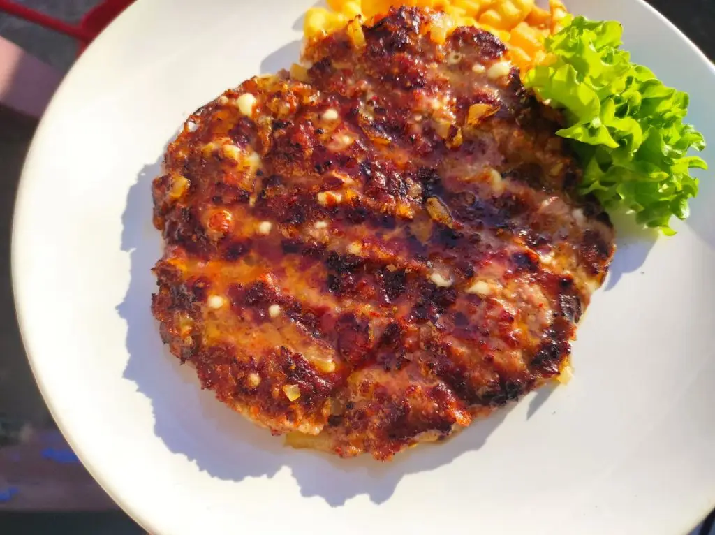 A perfectly grilled gourmet pljeskavica, showcasing the Serbian art of the burger